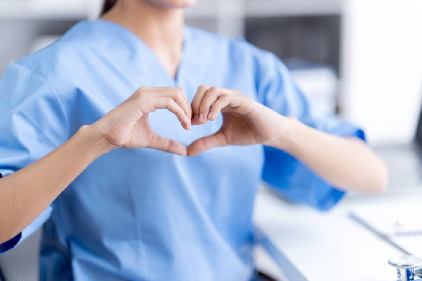 Female nurse using hands to gesture a heart shape